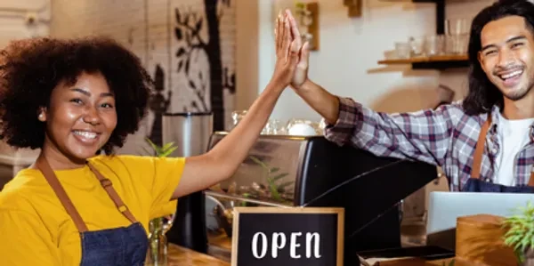 Two colleagues high-fiving — collaborative coaching partnership